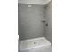 A modern shower with gray brick-patterned tile and a built-in shelf is showcased at 4651 Larkfield Way, Powder Springs, GA 30127