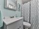 Well-maintained bathroom with modern fixtures, a framed mirror, and decorative shower curtain at 760 Oakdale Rd, Canton, GA 30114