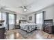 Serene bedroom features a ceiling fan, two windows with curtains, and wooden floors at 760 Oakdale Rd, Canton, GA 30114