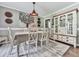 Charming dining room with a vintage hutch, table with white chairs, and decorative chandelier at 760 Oakdale Rd, Canton, GA 30114