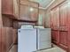 Functional laundry room with wood paneled walls, cabinets, and washer/dryer units at 760 Oakdale Rd, Canton, GA 30114