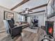 Comfortable living room with a fireplace, exposed beams, a ceiling fan, and hardwood floors at 760 Oakdale Rd, Canton, GA 30114
