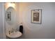 Stylish half bath with elegant fixtures and a round mirror above the sink at 7624 Squire Ct, Fairburn, GA 30213