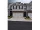 Charming townhome with a two-car garage, gray siding, and classic black shutters at 7624 Squire Ct, Fairburn, GA 30213