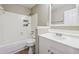 Bright bathroom with a white vanity, a bathtub, and white tile at 8227 Englewood Trl, Riverdale, GA 30274