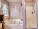 Bathroom featuring a soaking tub, a walk-in shower, and a window with natural light at 95 Loudoun Dr, Covington, GA 30014