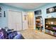 This cozy bedroom is painted in a tranquil blue, featuring a television, shelving, and carpeted floors at 95 Loudoun Dr, Covington, GA 30014