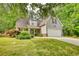 Traditional home with a two-car garage and a well-maintained lawn with mature trees and landscaping at 95 Loudoun Dr, Covington, GA 30014