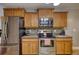 Kitchen boasts stainless steel appliances, wooden cabinets, and tile backsplash at 95 Loudoun Dr, Covington, GA 30014