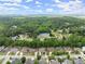 Aerial view of a neighborhood with beautiful green trees, pool and tennis courts at 2084 Democracy Dr, Buford, GA 30519