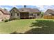 Back exterior view of home featuring a screened porch and a well maintained large lawn area at 2084 Democracy Dr, Buford, GA 30519