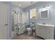 Bathroom featuring floral shower curtains, white vanity, and a window for natural light at 2084 Democracy Dr, Buford, GA 30519