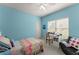 Bright bedroom with blue walls, a colorful quilt on the bed, and a work desk by the window at 2084 Democracy Dr, Buford, GA 30519
