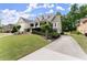 Charming home with a welcoming front porch, beautiful landscaping, and a long driveway leading to the garage at 2084 Democracy Dr, Buford, GA 30519
