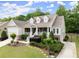 Charming home with a welcoming front porch, beautiful landscaping, and a long driveway leading to the garage at 2084 Democracy Dr, Buford, GA 30519