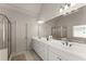 Light-filled bathroom features dual sinks, a glass shower, and a soaking tub for relaxation and convenience at 2084 Democracy Dr, Buford, GA 30519