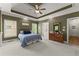 Spacious main bedroom featuring a tray ceiling, carpeted floors and an ensuite bathroom for a relaxing retreat at 2084 Democracy Dr, Buford, GA 30519
