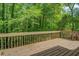 Spacious wooden deck showcasing a serene view of the surrounding woods and lush greenery at 3957 Woodland Cir, Conyers, GA 30013