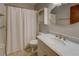 This bathroom offers a single sink vanity with modern faucet and a shower tub with a white curtain at 3957 Woodland Cir, Conyers, GA 30013