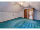 This bedroom features blue carpet, sloped ceilings, wood trim, and an adjacent hallway at 3957 Woodland Cir, Conyers, GA 30013