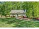 A well-manicured lawn and vibrant azaleas enhance the curb appeal of this home with light green paint and a blue front door at 3957 Woodland Cir, Conyers, GA 30013