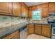 Kitchen with stainless steel dishwasher, granite countertops, and wood cabinets at 3957 Woodland Cir, Conyers, GA 30013