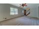 Bright living room featuring a ceiling fan, large window, and carpet flooring at 3957 Woodland Cir, Conyers, GA 30013
