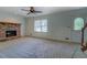 Bright living room featuring a red brick fireplace, ceiling fan, and carpet flooring at 3957 Woodland Cir, Conyers, GA 30013