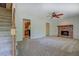 Open living area with carpet floors, white walls, a cozy fireplace, and a staircase to the second level at 3957 Woodland Cir, Conyers, GA 30013