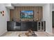 Finished basement bar with dark cabinets, wine cooler, and decorative wood paneling at 4206 Lake Laurel Se Dr, Smyrna, GA 30082