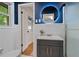 Charming bathroom with blue accent wall, modern vanity, and stylish round lighted mirror at 4206 Lake Laurel Se Dr, Smyrna, GA 30082