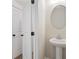 Modern bathroom features a pedestal sink, oval mirror, and neutral wall color at 4671 Larkfield Way, Powder Springs, GA 30127