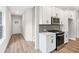 Well-lit kitchen area featuring white cabinets, stainless steel appliances, and durable laminate flooring at 4671 Larkfield Way, Powder Springs, GA 30127