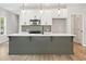 Stylish kitchen with a gray island, white cabinets, stainless steel appliances, and modern pendant lighting at 4671 Larkfield Way, Powder Springs, GA 30127