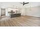 Spacious living room area with an eat-in kitchen, laminate floors, and modern lighting fixtures at 4671 Larkfield Way, Powder Springs, GA 30127