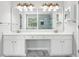 Bright bathroom featuring a double vanity with white cabinets and marble countertops at 3880 Lake Lanier Dr, Duluth, GA 30097