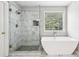 Modern bathroom showcasing a glass-enclosed shower with marble tiling and a standalone tub at 3880 Lake Lanier Dr, Duluth, GA 30097