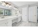 A bright bathroom includes a large mirror, double sinks, a vanity, and a glass shower at 3880 Lake Lanier Dr, Duluth, GA 30097