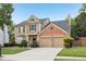 Charming two-story home with a two-car garage, brick accents, and a manicured front yard at 3880 Lake Lanier Dr, Duluth, GA 30097