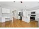 A modern kitchen features white cabinetry, an island, stainless steel appliances, and wood flooring at 3880 Lake Lanier Dr, Duluth, GA 30097