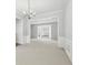 Open-concept living room with neutral carpet, large windows, and wainscoting at 3880 Lake Lanier Dr, Duluth, GA 30097
