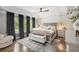 This primary bedroom offers hardwood floors, tray ceilings, decorative accent wall, and large windows with wooded views at 507 Southshore Ln, Dallas, GA 30157