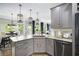 Bright kitchen features gray cabinetry, granite countertops, stainless steel appliances, and stylish lighting fixtures at 507 Southshore Ln, Dallas, GA 30157