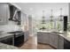 Modern kitchen with gray cabinets, stainless appliances, granite counters, hardwood floors, and ample natural light at 507 Southshore Ln, Dallas, GA 30157