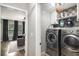 Convenient laundry room with stainless steel washer/dryer and elegant tile accents at 507 Southshore Ln, Dallas, GA 30157