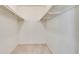 A view of an empty walk-in closet with white walls and shelving rods at 6851 Roswell Rd # H1, Sandy Springs, GA 30328