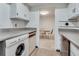 Washer and dryer appliances in kitchen, with doorway view to dining area at 6851 Roswell Rd # H1, Sandy Springs, GA 30328