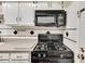 Close up of gas range stove and microwave in kitchen with diamond tile backsplash at 6851 Roswell Rd # H1, Sandy Springs, GA 30328