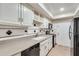 Classic kitchen with white cabinets, black appliances, and diamond tile backsplash at 6851 Roswell Rd # H1, Sandy Springs, GA 30328