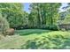 Expansive backyard featuring lush greenery, mature trees, and a well-manicured lawn, creating a private outdoor oasis at 168 Woodland Valley Rd, Lawrenceville, GA 30046